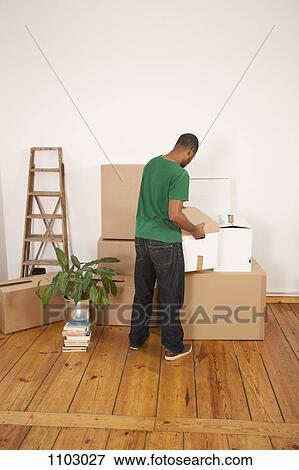 A man lifting a moving box to put it on top of other boxes View Large Photo Image Stock Photo - A man lifting a moving box to put it on top of other boxes. Fotosearch