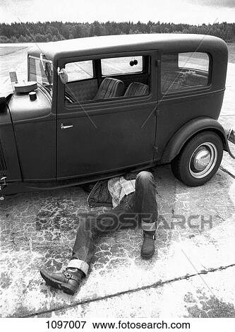 A man repairing an old car View Large Photo Image Stock Photo - A man repairing an old car. Fotosearch