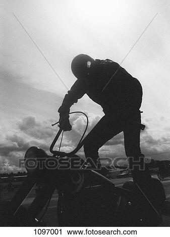 A man standing on a motorcycle View Large Photo Image Stock Image - A man standing on a motorcycle. Fotosearch