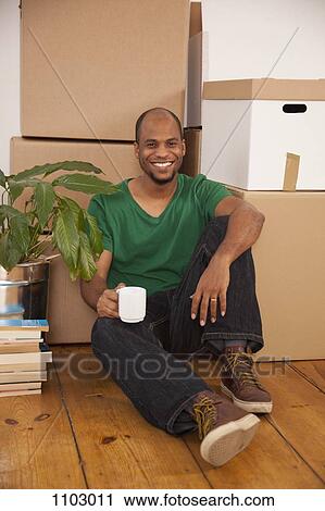 A man taking a coffee break while moving house View Large Photo Image Stock Image - A man taking a coffee break while moving house. Fotosearch