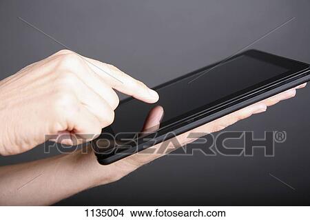 A man using a digital tablet, close-up of hand View Large Photo Image Picture - A man using a digital tablet, close-up of hand. Fotosearch