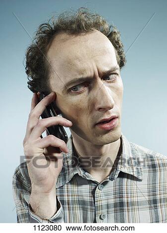 A man using a mobile phone and looking worried View Large Photo Image Stock Image - A man using a mobile phone and looking worried. Fotosearch