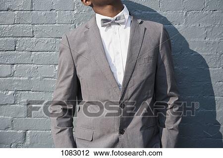 A man wearing a bow tie and suit, midsection View Large Photo Image Stock Image - A man wearing a bow tie and suit, midsection. Fotosearch