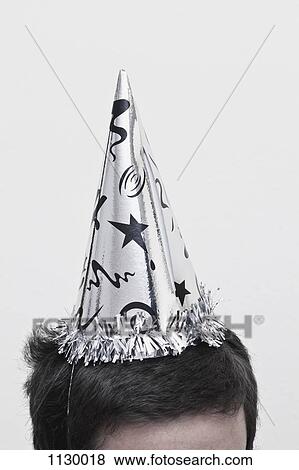 A man wearing a New Year's Eve party hat, top of head View Large Photo Image Stock Photo - A man wearing a New Year's Eve party hat, top of head. Fotosearch