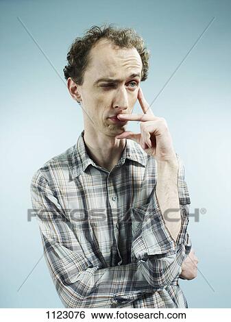 A man with an expression of uncertainty, looking away View Large Photo Image Stock Photograph - A man with an expression of uncertainty, looking away. Fotosearch
