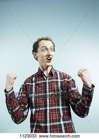 A man with his fists clenched in celebration View Large Photo Image Stock Image - A man with his fists clenched in celebration. Fotosearch
