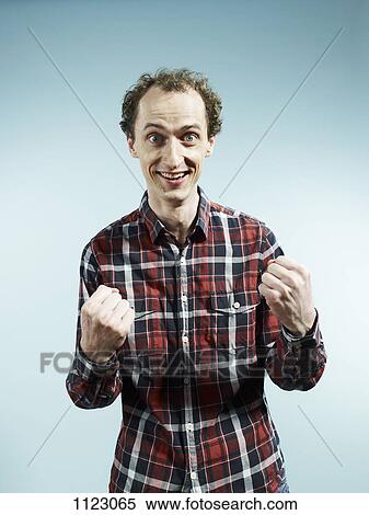 A man with his hands clenched in fists in success View Large Photo Image Stock Photography - A man with his hands clenched in fists in success. Fotosearch