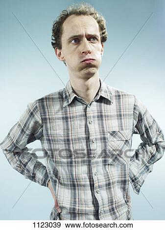 A man with puffed cheeks looking away with uncertainty View Large Photo Image Stock Photo - A man with puffed cheeks looking away with uncertainty. Fotosearch