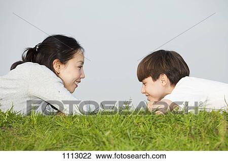 A mother and son lying on their stomachs face to face View Large Photo Image Stock Image - A mother and son lying on their stomachs face to face. Fotosearch