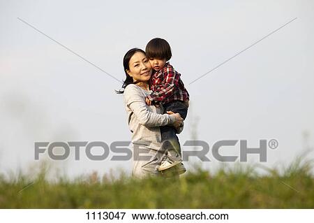 A mother carrying her son outdoors View Large Photo Image Stock Photo - A mother carrying her son outdoors. Fotosearch