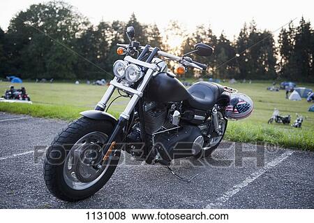 A motorcycle parked in a parking space at a park View Large Photo Image Stock Photo - A motorcycle parked in a parking space at a park. Fotosearch