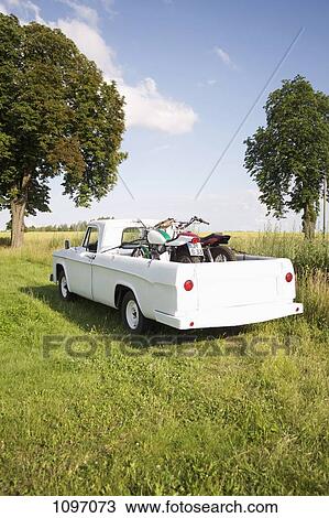 A pickup truck with motorbikes in a field View Large Photo Image Stock Image - A pickup truck with motorbikes in a field. Fotosearch