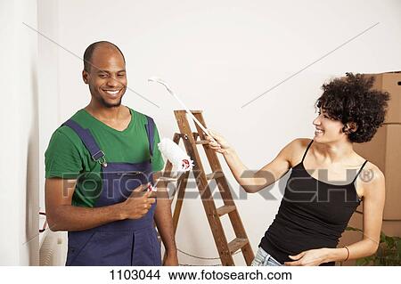 A playful couple having fun while painting apartment View Large Photo Image Picture - A playful couple having fun while painting apartment. Fotosearch