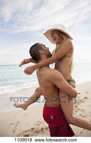 A playful young couple at the beach View Large Photo Image Stock Photo - A playful young couple at the beach. Fotosearch
