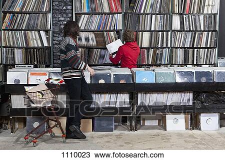 Stock Image - A sales clerk helping a customer in a record store. Fotosearch