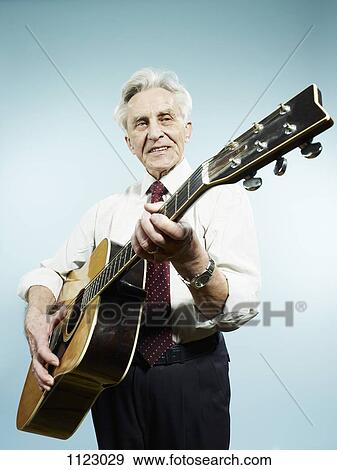 A senior man playing an acoustic guitar View Large Photo Image Stock Photo - A senior man playing an acoustic guitar. Fotosearch