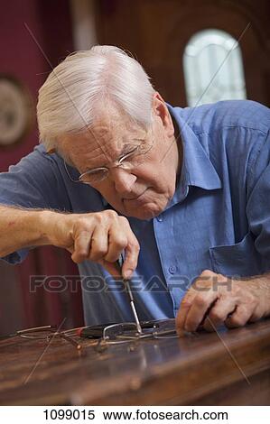 A senior man repairing a pair of glasses View Large Photo Image Stock Photography - A senior man repairing a pair of glasses. Fotosearch