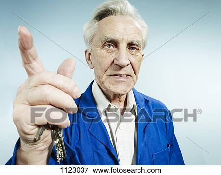 A senior man wearing coveralls and pointing while talking View Large Photo Image Stock Photo - A senior man wearing coveralls and pointing while talking. Fotosearch