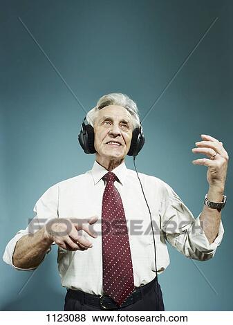 A senior man wearing headphones and playing air guitar View Large Photo Image Stock Photo - A senior man wearing headphones and playing air guitar. Fotosearch