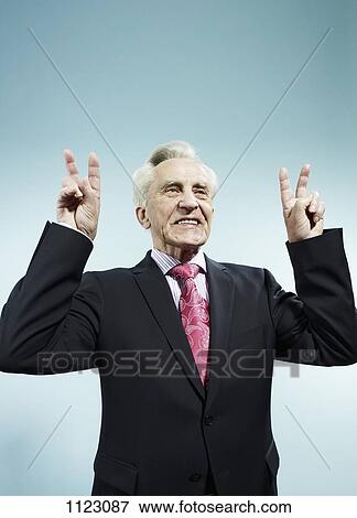 A senior man with both hands raised making peace signs View Large Photo Image Stock Photo - A senior man with both hands raised making peace signs. Fotosearch