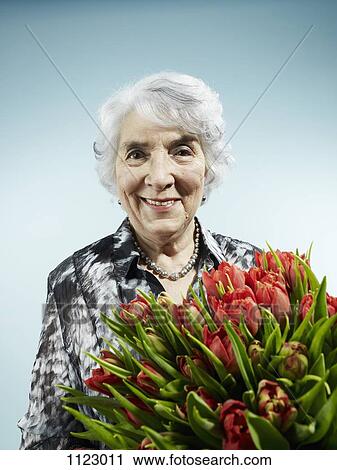 A senior woman receiving a bouquet of tulips View Large Photo Image Stock Image - A senior woman receiving a bouquet of tulips. Fotosearch