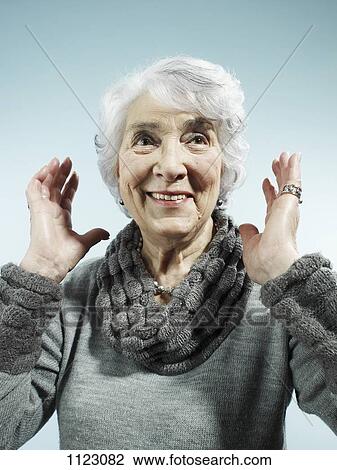 A senior woman with her arms raised in surprise View Large Photo Image Stock Image - A senior woman with her arms raised in surprise. Fotosearch