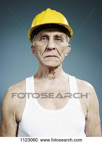 A serious senior man wearing a hardhat and tank top View Large Photo Image Stock Image - A serious senior man wearing a hardhat and tank top. Fotosearch