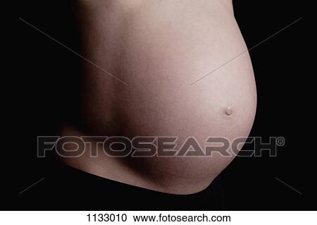 A shirtless pregnant woman, midsection View Large Photo Image Stock Image - A shirtless pregnant woman, midsection. Fotosearch