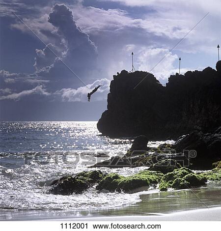 A silhouetted person diving off a cliff, Maui, Hawaii View Large Photo Image Stock Image - A silhouetted person diving off a cliff, Maui, Hawaii. Fotosearch