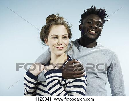 A smiling young man embracing his smiling girlfriend from behind View Large Photo Image Stock Image - A smiling young man embracing his smiling girlfriend from behind. Fotosearch