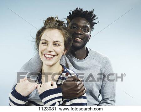 A smiling young man embracing his smiling girlfriend from behind View Large Photo Image Stock Image - A smiling young man embracing his smiling girlfriend from behind. Fotosearch