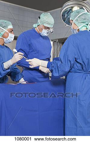 A surgery team operating on a patient in an operating room View Large Photo Image Stock Image - A surgery team operating on a patient in an operating room. Fotosearch