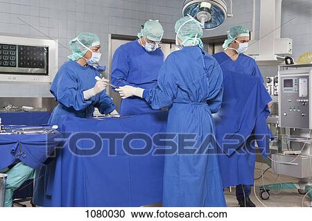 A surgery team operating on a patient in an operating room View Large Photo Image Stock Image - A surgery team operating on a patient in an operating room. Fotosearch