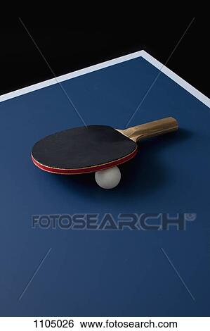 Stock Photograph - A table tennis bat and ball on a table. Fotosearch