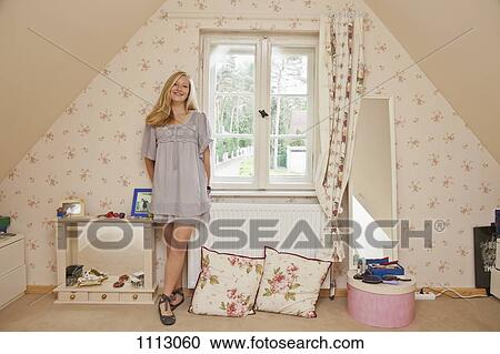 A teenage girl standing in her bedroom smiling View Large Photo Image Stock Image - A teenage girl standing in her bedroom smiling. Fotosearch