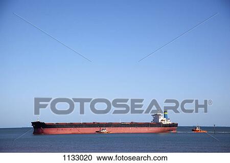 A tugboat pulling a freight ship View Large Photo Image Stock Image - A tugboat pulling a freight ship. Fotosearch