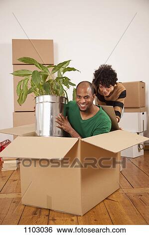 A woman pushing a man sitting inside of a moving box View Large Photo Image Stock Photograph - A woman pushing a man sitting inside of a moving box. Fotosearch