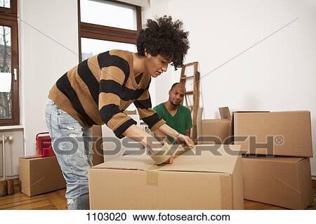 A woman taping a moving box while a man watches View Large Photo Image Stock Image - A woman taping a moving box while a man watches. Fotosearch