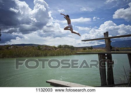 A young boy jumping into a lake View Large Photo Image Stock Image - A young boy jumping into a lake. Fotosearch