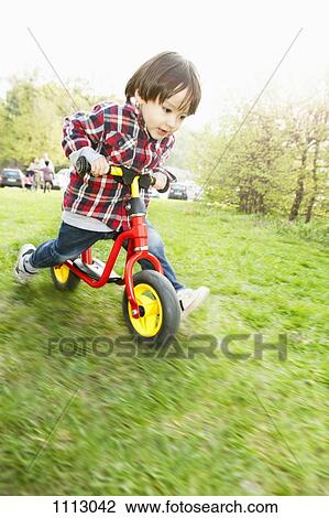 A young boy running on a balance bicycle View Large Photo Image Stock Image - A young boy running on a balance bicycle. Fotosearch
