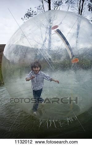 A young boy walking in an inflatable walking water ball View Large Photo Image Stock Image - A young boy walking in an inflatable walking water ball. Fotosearch