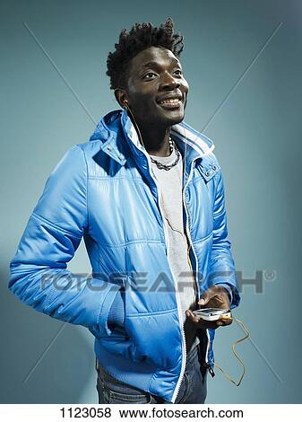 A young hip man wearing a vintage ski jacket and listening to a MP3 player View Large Photo Image Stock Photo - A young hip man wearing a vintage ski jacket and listening to a MP3 player. Fotosearch
