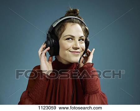 A young hip woman wearing headphones and smiling View Large Photo Image Stock Photo - A young hip woman wearing headphones and smiling. Fotosearch