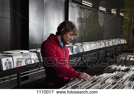 A young man looking through records at a record store View Large Photo Image Stock Photo - A young man looking through records at a record store. Fotosearch