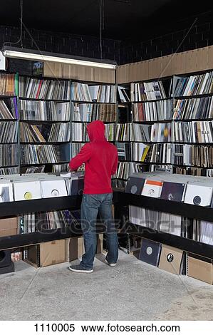 A young man looking through records at a record store, rear view View Large Photo Image Stock Photography - A young man looking through records at a record store, rear view. Fotosearch