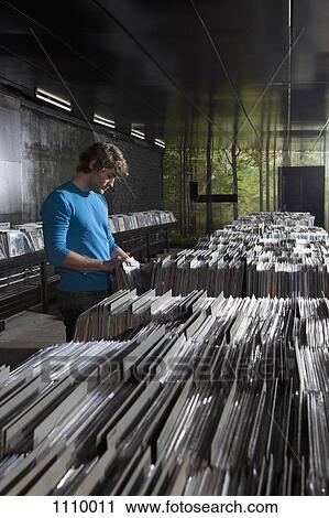 A young man searching through records in a record store View Large Photo Image Stock Image - A young man searching through records in a record store. Fotosearch