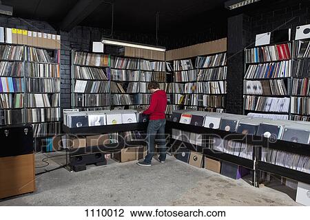 A young man searching through records, rear view View Large Photo Image Stock Image - A young man searching through records, rear view. Fotosearch