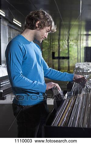 A young man shopping in a record store View Large Photo Image Stock Image - A young man shopping in a record store. Fotosearch