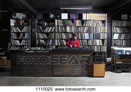 A young man using decks and a sound mixer at a record store View Large Photo Image Stock Image - A young man using decks and a sound mixer at a record store. Fotosearch