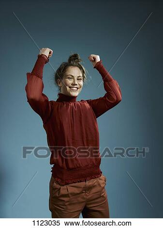 A young woman with her arms raised in celebration View Large Photo Image Stock Photography - A young woman with her arms raised in celebration. Fotosearch